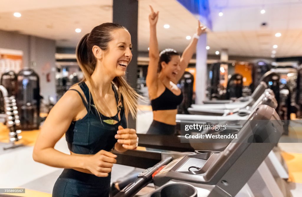 Chica deportiva en ropa deportiva roja corre en cinta de correr en el gimnasio  mujer entrena en la sala de fitness