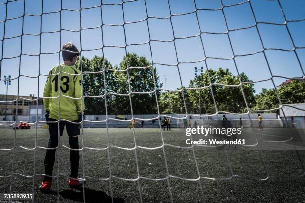 boy as soccer goalkeeper - boy goalie standing in front of goal net stock pictures, royalty-free photos & images