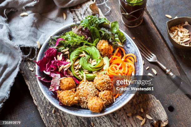 rainbow salad bowl with carrots, lettuce, avocado, millet falafel and moroccan mint tea - saladekom stockfoto's en -beelden