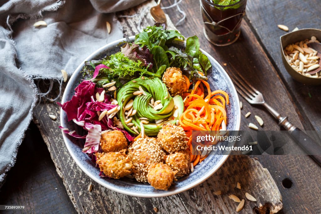Rainbow salad bowl with carrots, lettuce, avocado, millet falafel and Moroccan mint tea