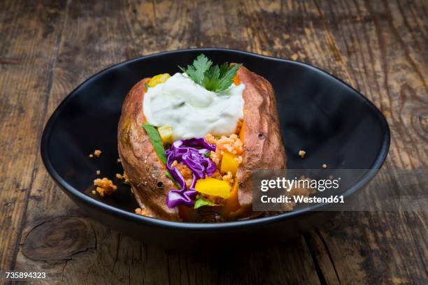 sweet potato kumpir withbell pepper, red cabbage, couscous, yoghurt sauce and parsley - joghurtsoße stock-fotos und bilder