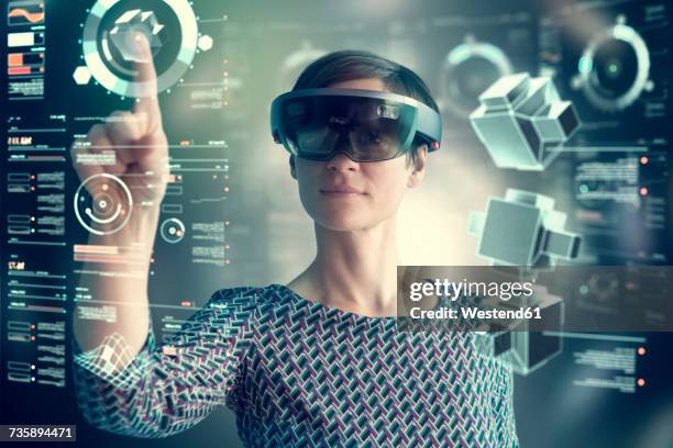 woman wearing mixed reality smartglasses touching transparent screen - smart glasses stock pictures, royalty-free photos & images