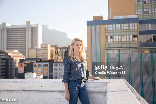 young woman standing on a rooftop terrace - balustrade stock pictures, royalty-free photos & images