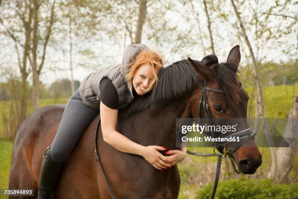 smiling young woman riding horse - bending stock pictures, royalty-free photos & images