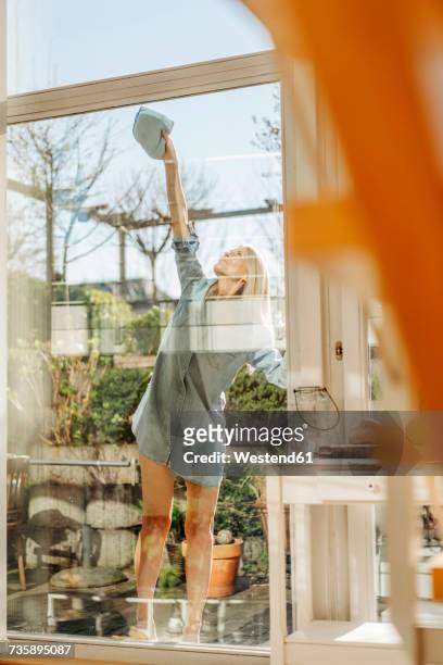 woman cleaning the window - people cleaning at home stock-fotos und bilder