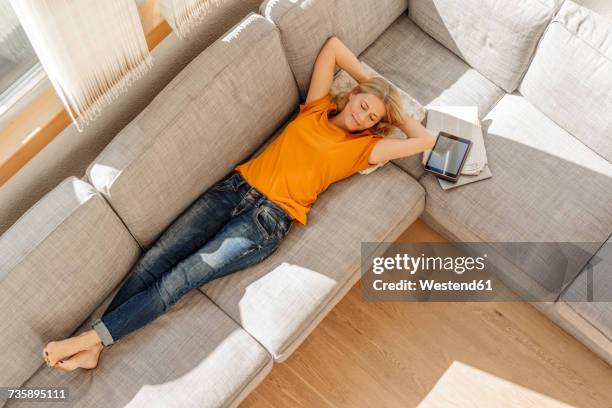 woman at home lying on couch - 50 sombras fotografías e imágenes de stock