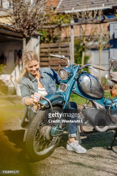 smiling woman cleaning vintage motorcycle - motorbike wash stock pictures, royalty-free photos & images