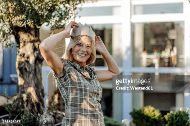 happy woman in garden wearing a crown - königin stock-fotos und bilder