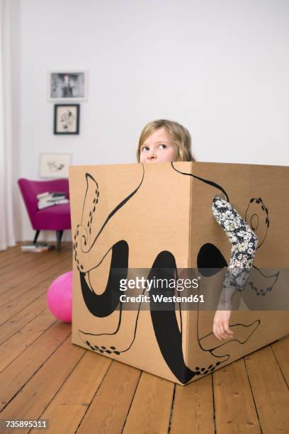 girl inside a cardboard box painted with an octopus - boxes home stock-fotos und bilder