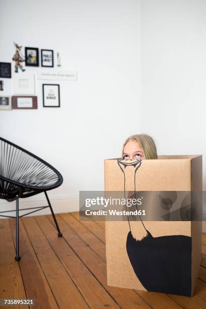 Girl inside a cardboard box painted with an ostrich