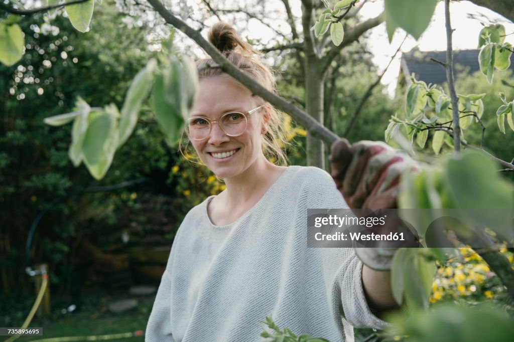 Portrait of young woman holding branch of her quince tree