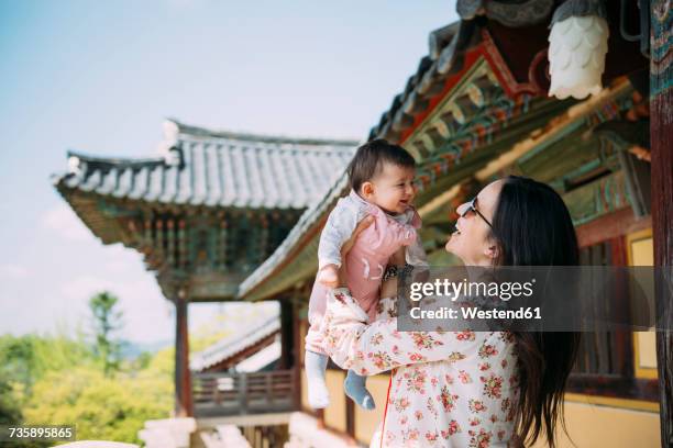 south korea, gyeongju, woman traveling with a baby girl in bulguksa temple - korean baby girl stock-fotos und bilder