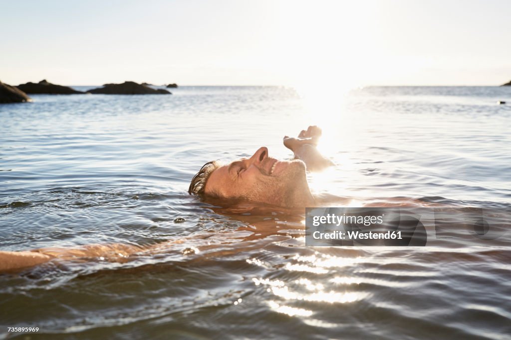 Happy mature man floating in the sea