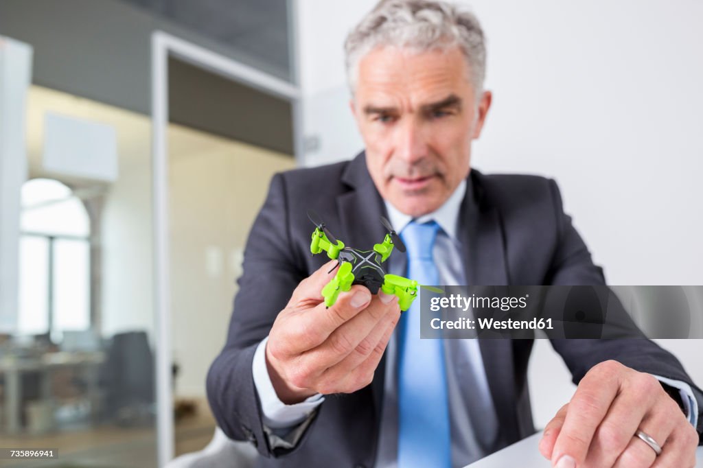 Mature businessman looking at drone