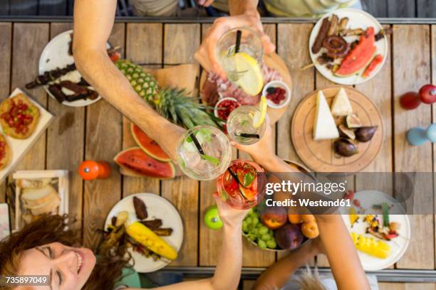 friends clinking glasses above outdoor table - coctail party stockfoto's en -beelden