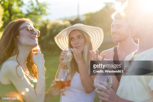 four friends drinking and talking in the garden - 4 cocktails stockfoto's en -beelden