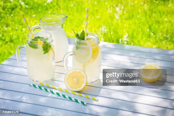 two glasses of cooled lemonade flavoured with lemon balm - rietje stockfoto's en -beelden