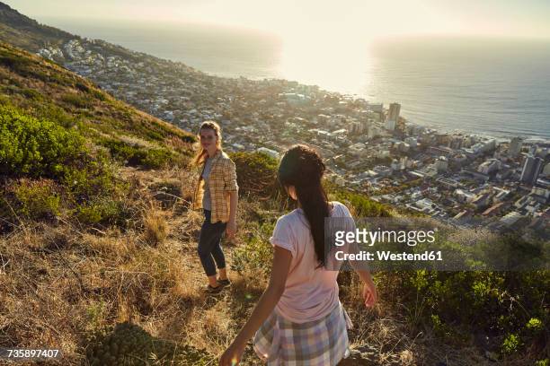 South Africa, Cape Town, Signal Hill, two young women hiking above the city