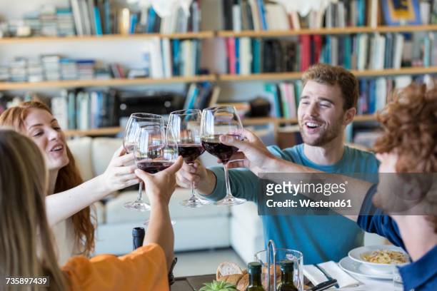 friends toasting with red wine - four people foto e immagini stock