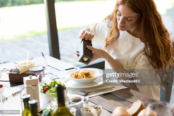 woman seasoning her spaghetti carbonara - carbonara stock pictures, royalty-free photos & images