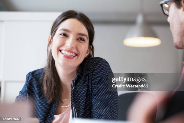 smiling woman looking at man in office - zwei frauen lachen stock-fotos und bilder