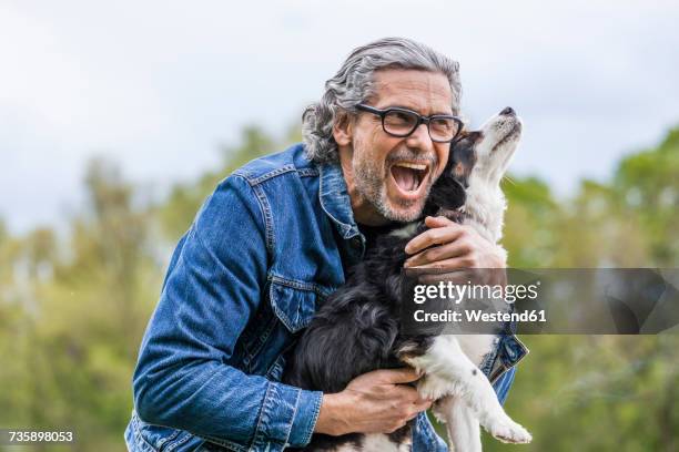 portrait of happy senior man cuddling his dog - westend61 fotografías e imágenes de stock