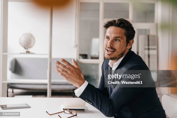 businessman talking in office - indicating ストックフォトと画像