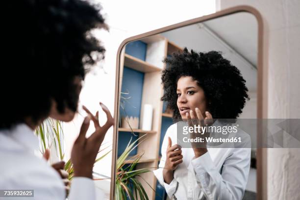 young woman applying lip care - trucco per il viso foto e immagini stock