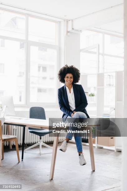 young businesswoman sitting in her office - business woman sitting stock-fotos und bilder