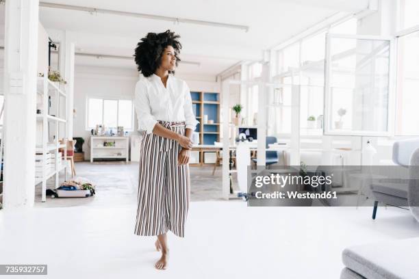 young woman standing in her apartment, looking confident - fashionable businesswoman stock pictures, royalty-free photos & images