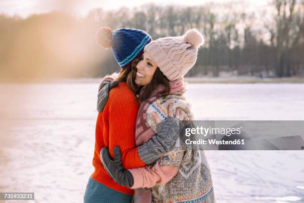 friends hugging on frozen lake - cologne winter stock pictures, royalty-free photos & images