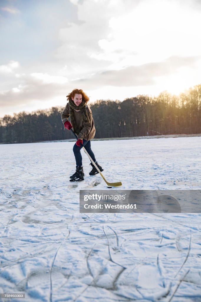 Man playing ice hockey on frozen lake