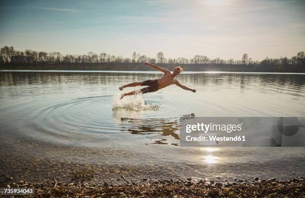 germany, bavaria, feldkirchen, man jumping in lake - sprung ins wasser stock-fotos und bilder