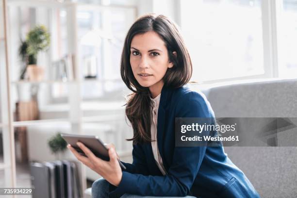 portrait of businesswoman with tablet on couch - one mid adult woman only stock pictures, royalty-free photos & images