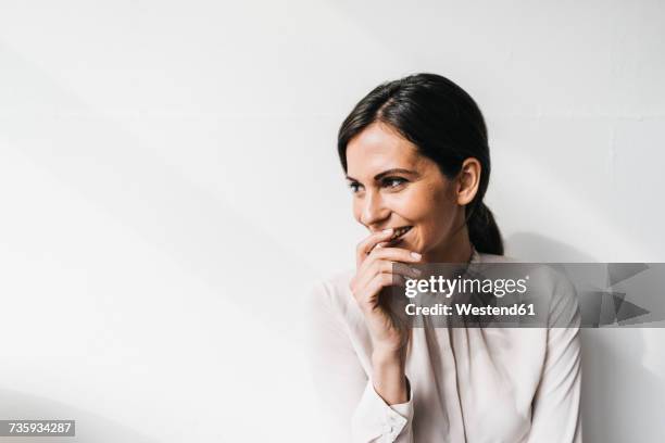 happy woman in front of white wall - adulto de mediana edad fotografías e imágenes de stock