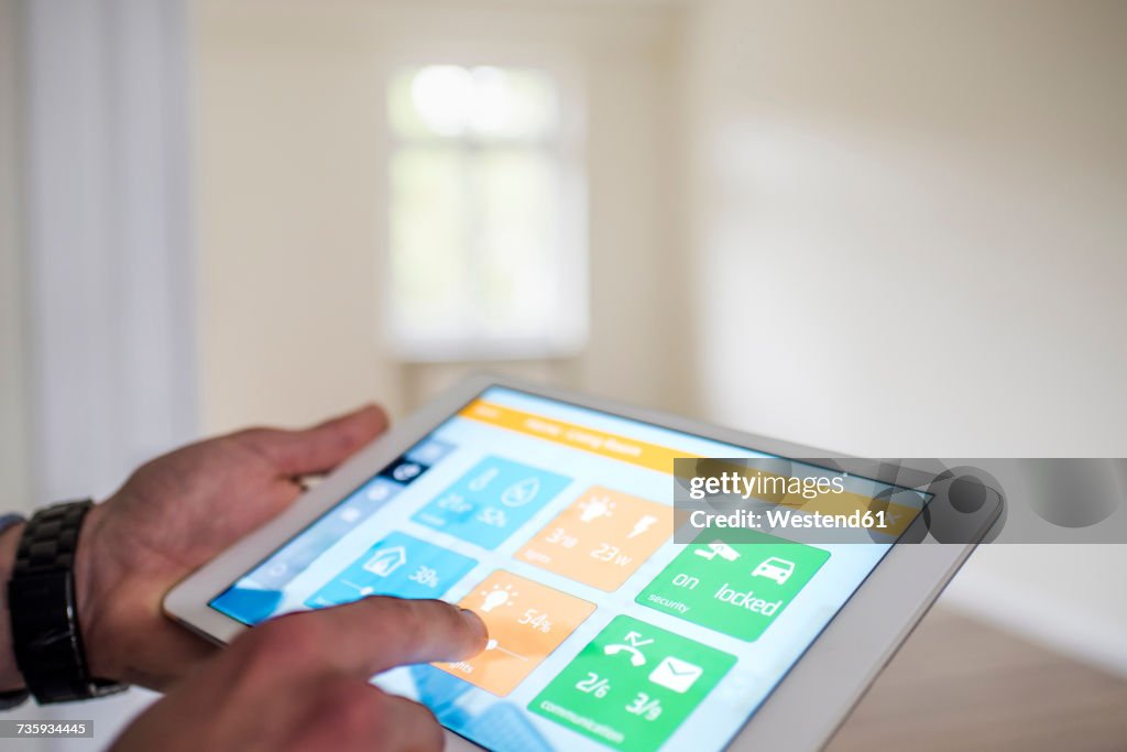 Man in new home using tablet with smart home apps