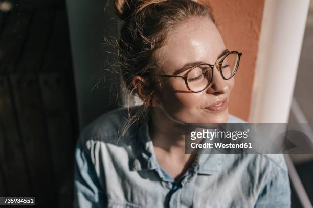 young woman with glasses in sunlight - soddisfazione foto e immagini stock