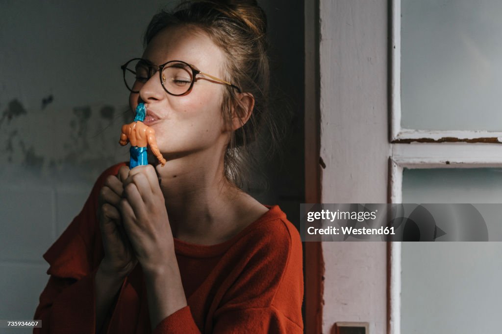 Young woman kissing superhero comic figurine