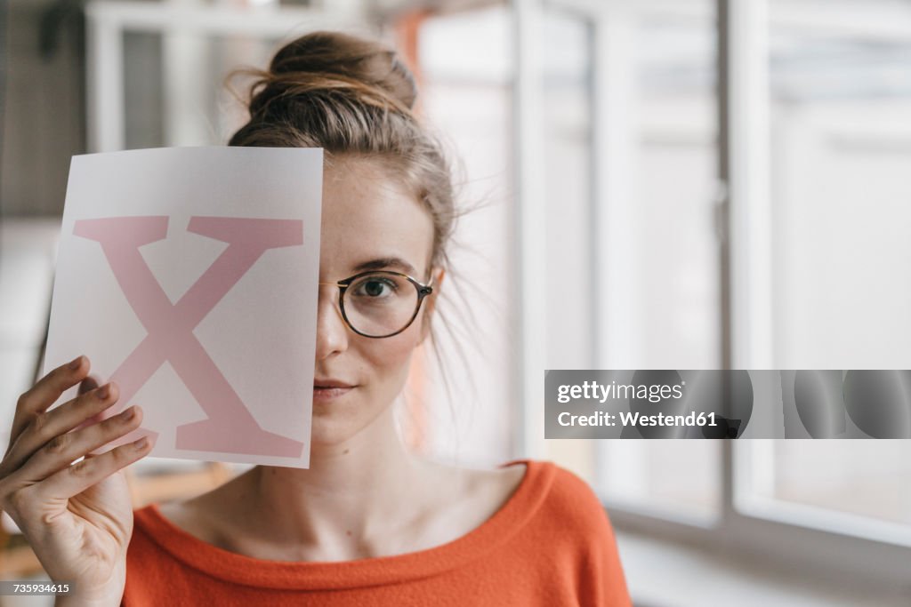 Portrait of young woman holding letter x template