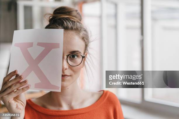 portrait of young woman holding letter x template - letter x stock pictures, royalty-free photos & images