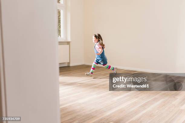 happy girl running in empty apartment - bambini che corrono foto e immagini stock