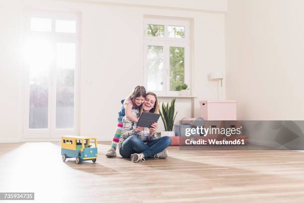 happy girl and mother with tablet in empty apartment - camera bambino foto e immagini stock