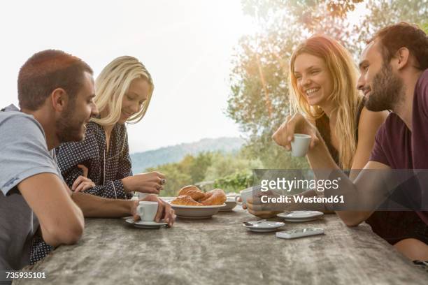 two couples having fun at breakfast table - four people foto e immagini stock