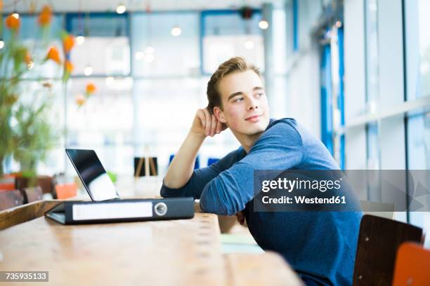 portrait of student sitting in a coffee shop watching something - business recovery stock pictures, royalty-free photos & images