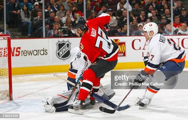 Chris Kelly of the Ottawa Senators dekes around Mike Dunham of the New York Islanders to score the opening goal of the game during second period...