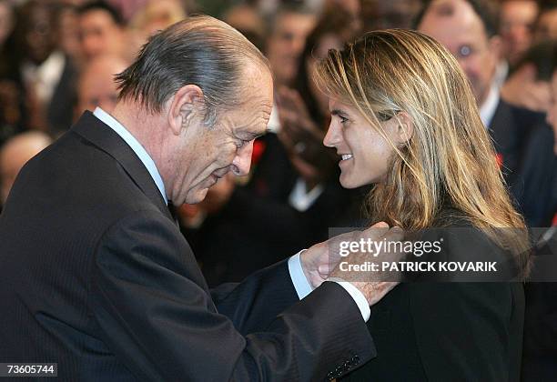 French President Jacques Chirac awards French tennis player Amelie Mauresmo with the insigna of knight of Legion of Honor 16 March 2007 at the...