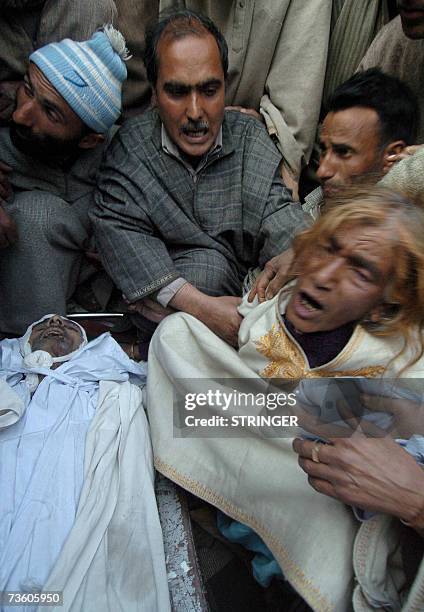 Kashmiri woman is comforted as she grieves near the body of her relative Gulam Nabi during his funeral cermony in Botingoo, some 56kms north of...