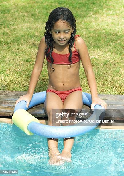 girl sitting on edge of swimming pool - olive skin tone stock pictures, royalty-free photos & images