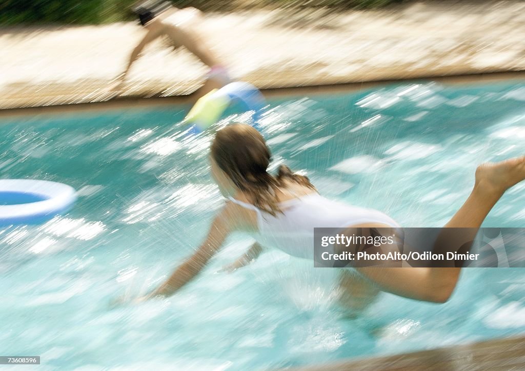 Girl jumping into swimming pool