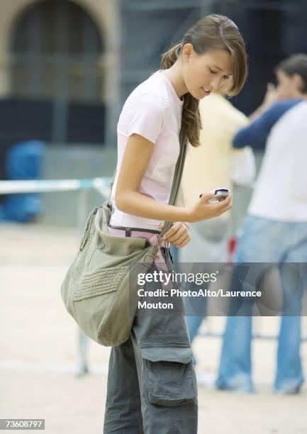 teen girl looking at cell phone - borsa a tracolla foto e immagini stock